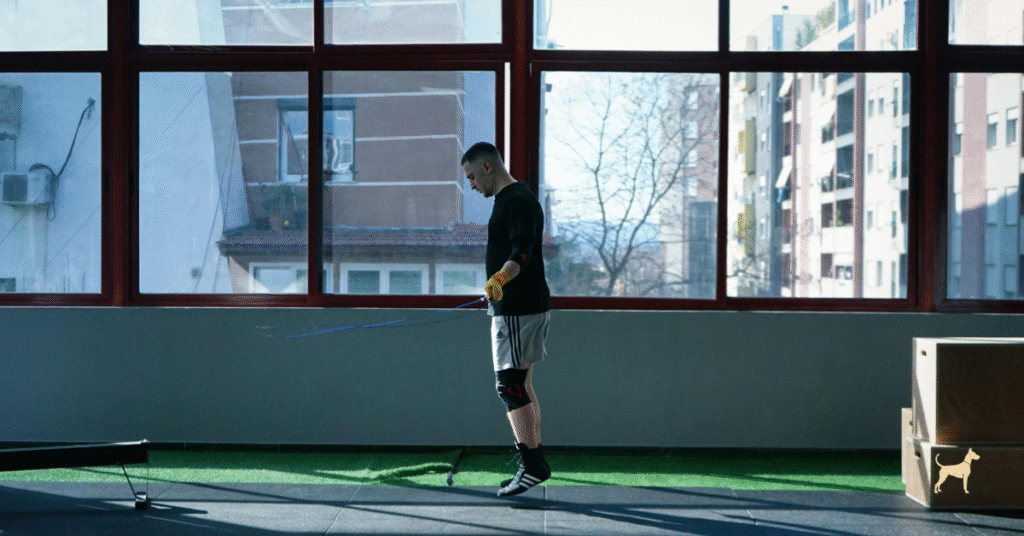 Silhouette of a man skipping rope in a minimalist boxing gym, focused and composed in morning light